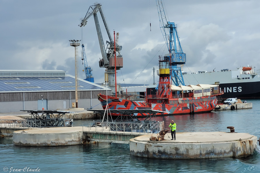 Un pêcheur de loisir dans le port de Sète. En arrière plan l'ancien bateau-phare.